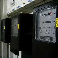 Trzy liczniki energii elektrycznej, każdy pokazujący inną jednostkę energii. Jeden z nich wskazuje 3104572 kWh.