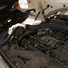 Mechanik sprawdza silnik, szukając objawów uszkodzonego termostatu.