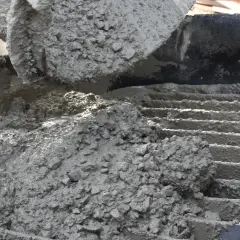 Świeży, mokry beton z kruszywem wylewany na ruszt.