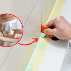Aplikacja środka do usuwania silikonu na dłoni i jego rozprowadzanie narzędziem do fugowania.