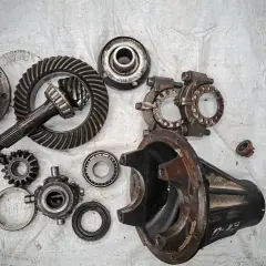Rozłożony mechanizm różnicowy, w tym koła zębate i łożyska. Widoczne elementy mogą wskazywać na uszkodzony zawór różnicowy objawy.