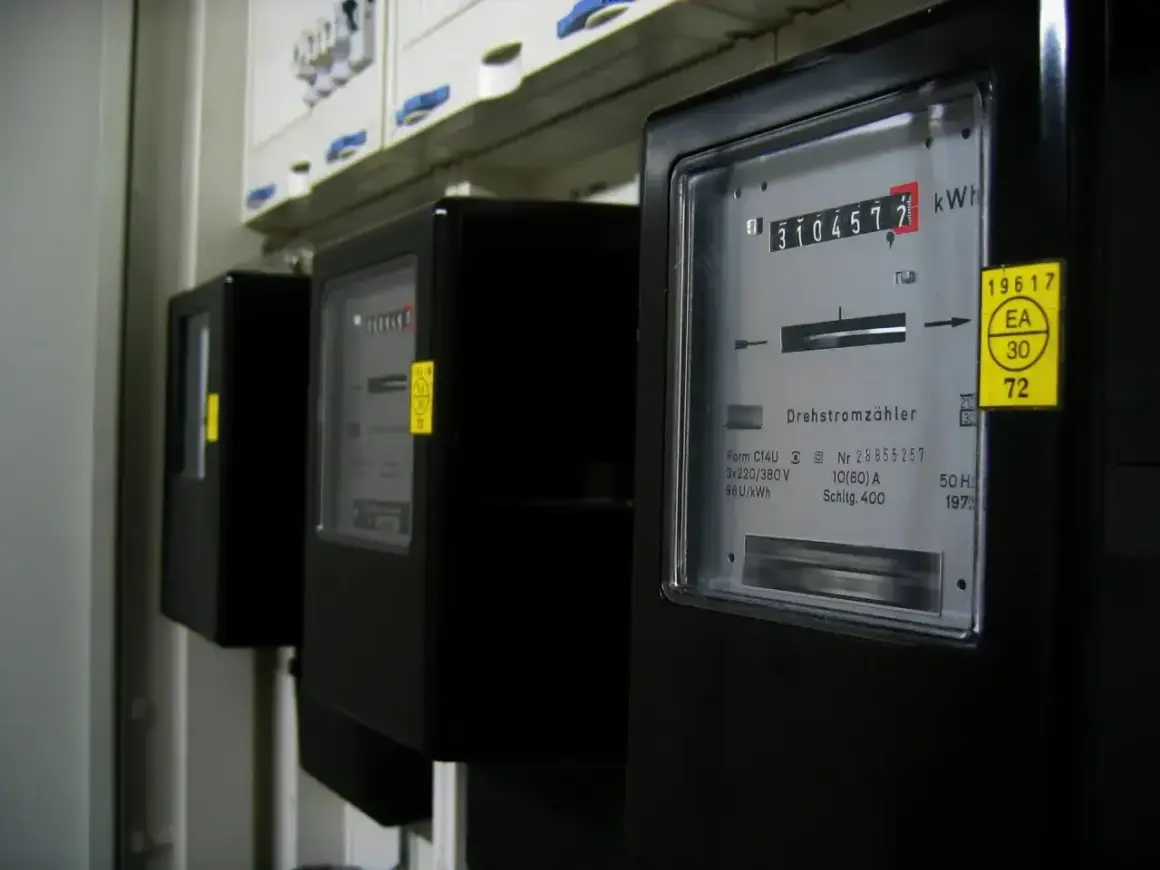 Trzy liczniki energii elektrycznej, każdy pokazujący inną jednostkę energii. Jeden z nich wskazuje 3104572 kWh.