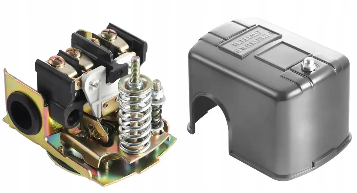 Mechanizm presostatu z elementami sprężynowymi i zaciskami, obok metalowa osłona z napisem "PRESSURE SWITCH".