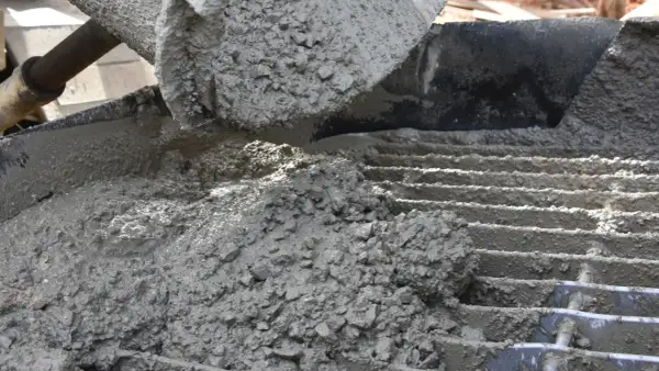 Świeży, mokry beton z kruszywem wylewany na ruszt.