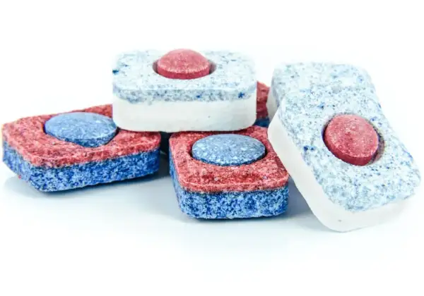 Kilka kostek do zmywarki w kolorach czerwonym, niebieskim i białym. Co zamiast tabletki do zmywarki? Te kostki to rozwiązanie!